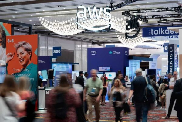 Event attendees walking around a convention center floor with company logos and booths spread around them.