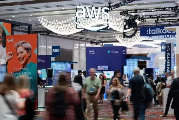 Event attendees walking around a convention center floor with company logos and booths spread around them.