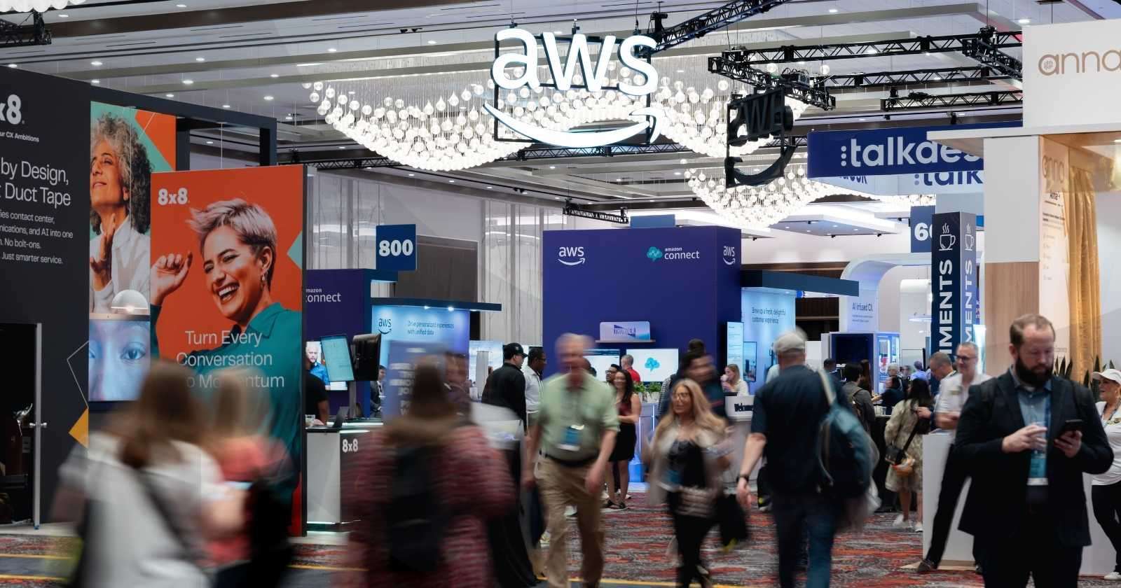Event attendees walking around a convention center floor with company logos and booths spread around them.
