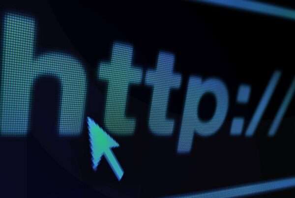 A website URL in white text on a black screen with a computer mouse hovering over it.