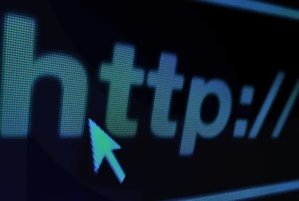 A website URL in white text on a black screen with a computer mouse hovering over it.