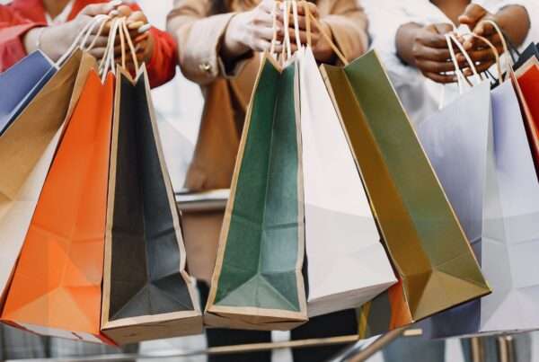 Happy shoppers carry shopping bags at a shopping mall