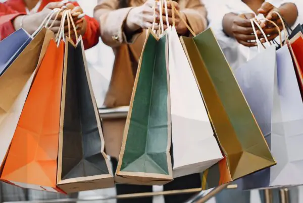 Happy shoppers carry shopping bags at a shopping mall